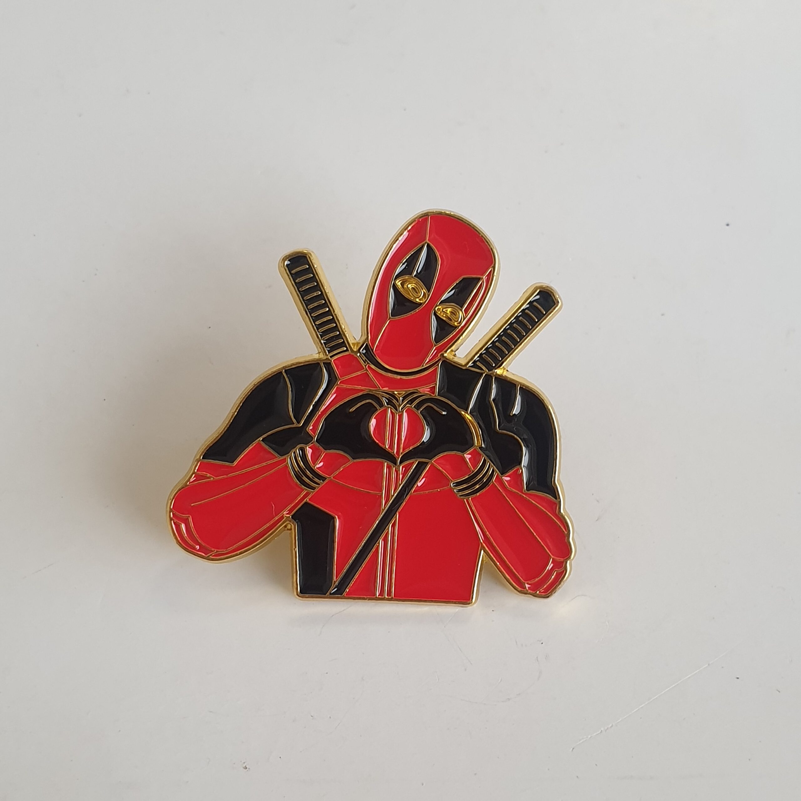 Heart-shaped badge with Spiderman's hand symbol.